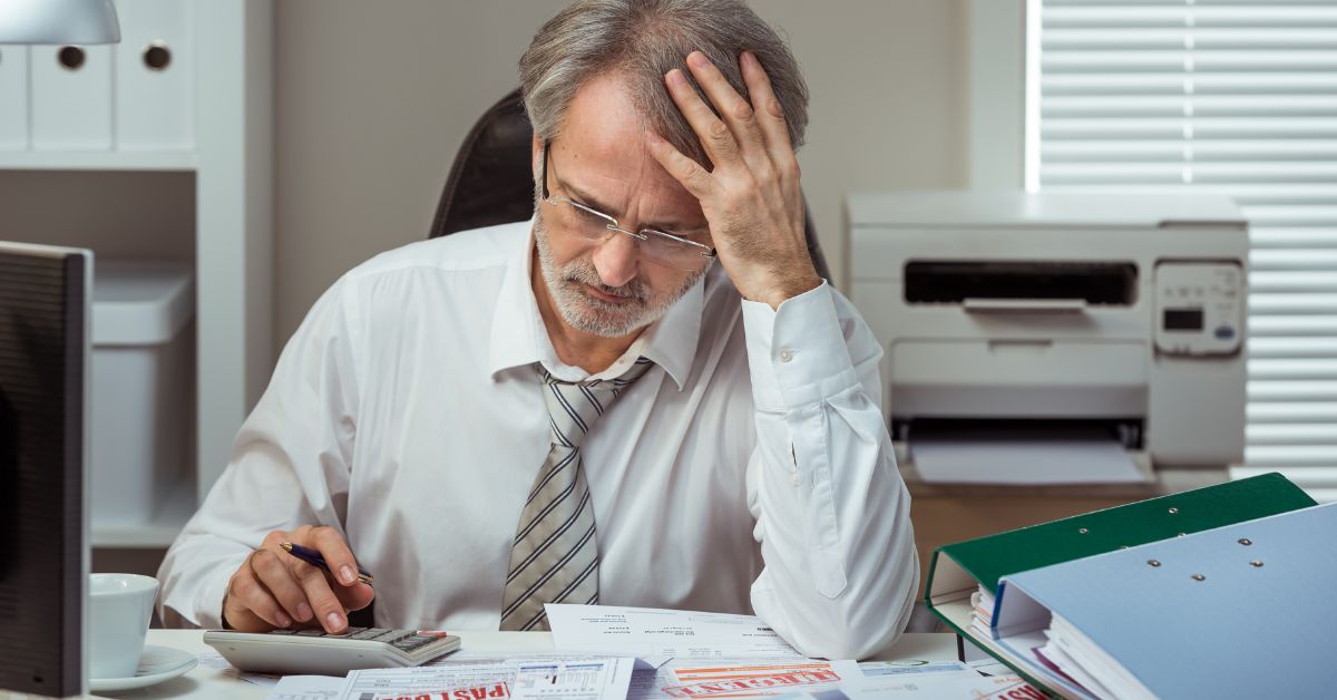 frustrated man looking at documents